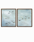 Set of 2 Flight - Flight I and II is a set of two abstract bird paintings featuring birds in flight against a softly textured cloudy sky in light blue, blue gray, cream, white, warm beige, brown, charcoal gray, and soft black; walnut oak frame by NLS Design. Large neutral gallery wall art for living rooms, bedrooms, entryways, offices, and above the couch and above the bed. Horizontal Sizes: 8x10, 11x14, 16x20, 18x24, 24x36, 30x40, 40x60 inches. nlsdesignllc.com. Real art by a real artist - NO AI