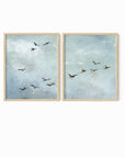 Set of 2 Flight - Flight I and II is a set of two abstract bird paintings featuring birds in flight against a softly textured cloudy sky in light blue, blue gray, cream, white, warm beige, brown, charcoal gray, and soft black; natural oak frame by NLS Design. Large neutral gallery wall art for living rooms, bedrooms, entryways, offices, and above the couch and above the bed. Horizontal Sizes: 8x10, 11x14, 16x20, 18x24, 24x36, 30x40, 40x60 inches.  nlsdesignllc.com. Real art by a real artist - NO AI